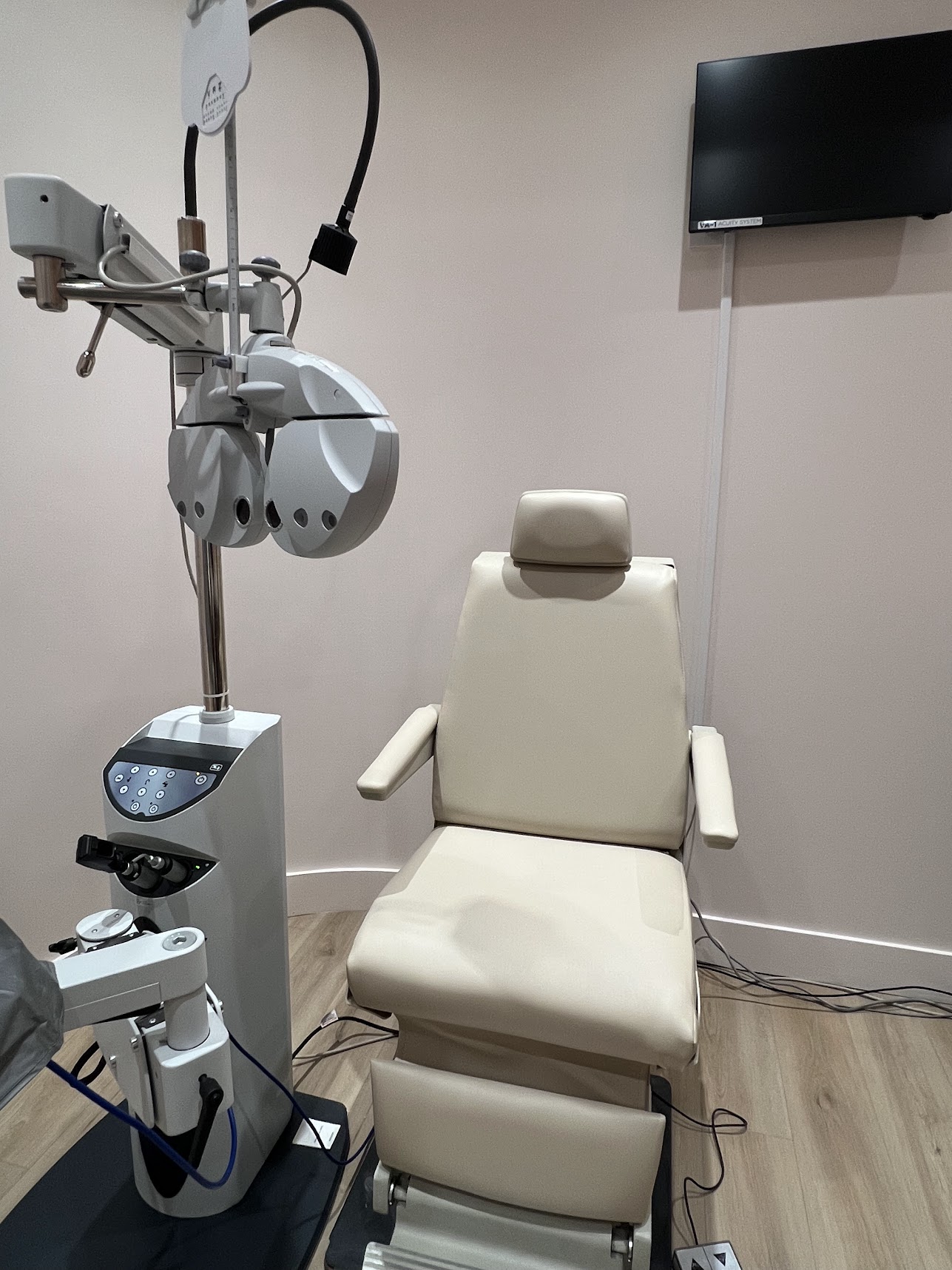 Beige upholstered ophthalmic examination chair in an eye examination room.